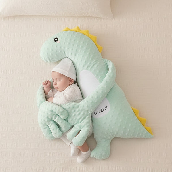 Baby sleeping under a dinosaur-shaped comfort pillow.